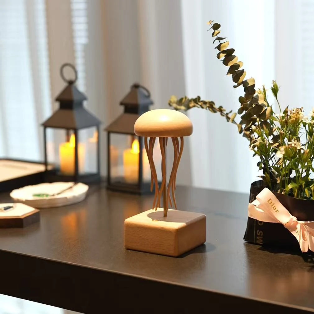 Jellyfish automaton on a dark table beside two lanterns and a green sprig.