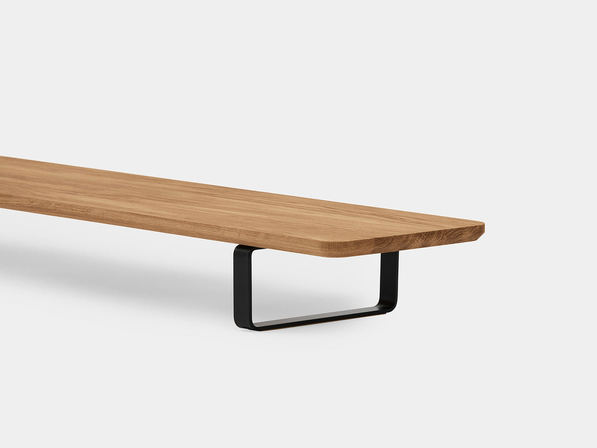 Close-up of the oak shelf edge and a black U-shaped leg