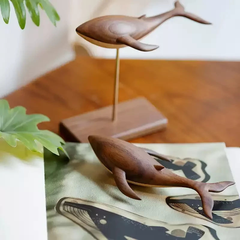The standing whale on its brass rod and the floating whale below it, plants and a whale print around them.