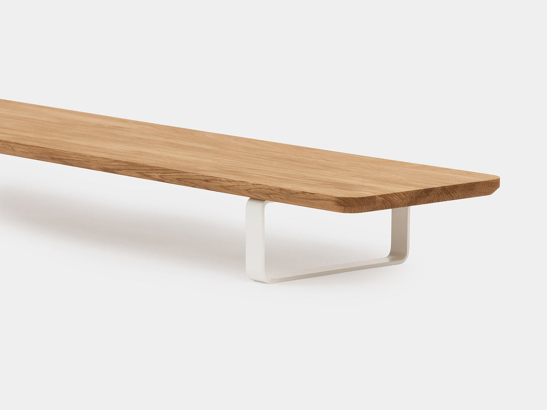 Close-up of the oak shelf edge and a white U-shaped leg