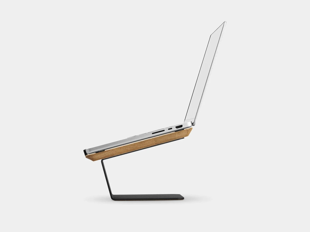 Side view of an open laptop on the oak riser