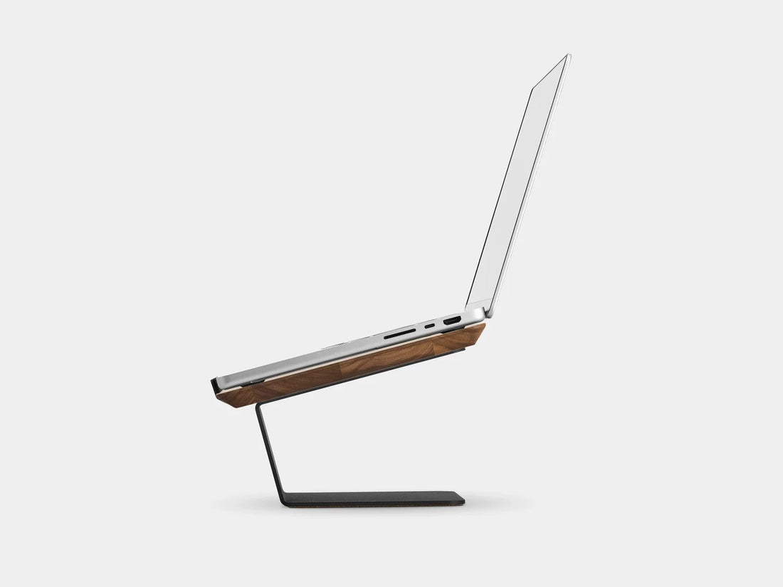 Side view of an open laptop on the walnut riser