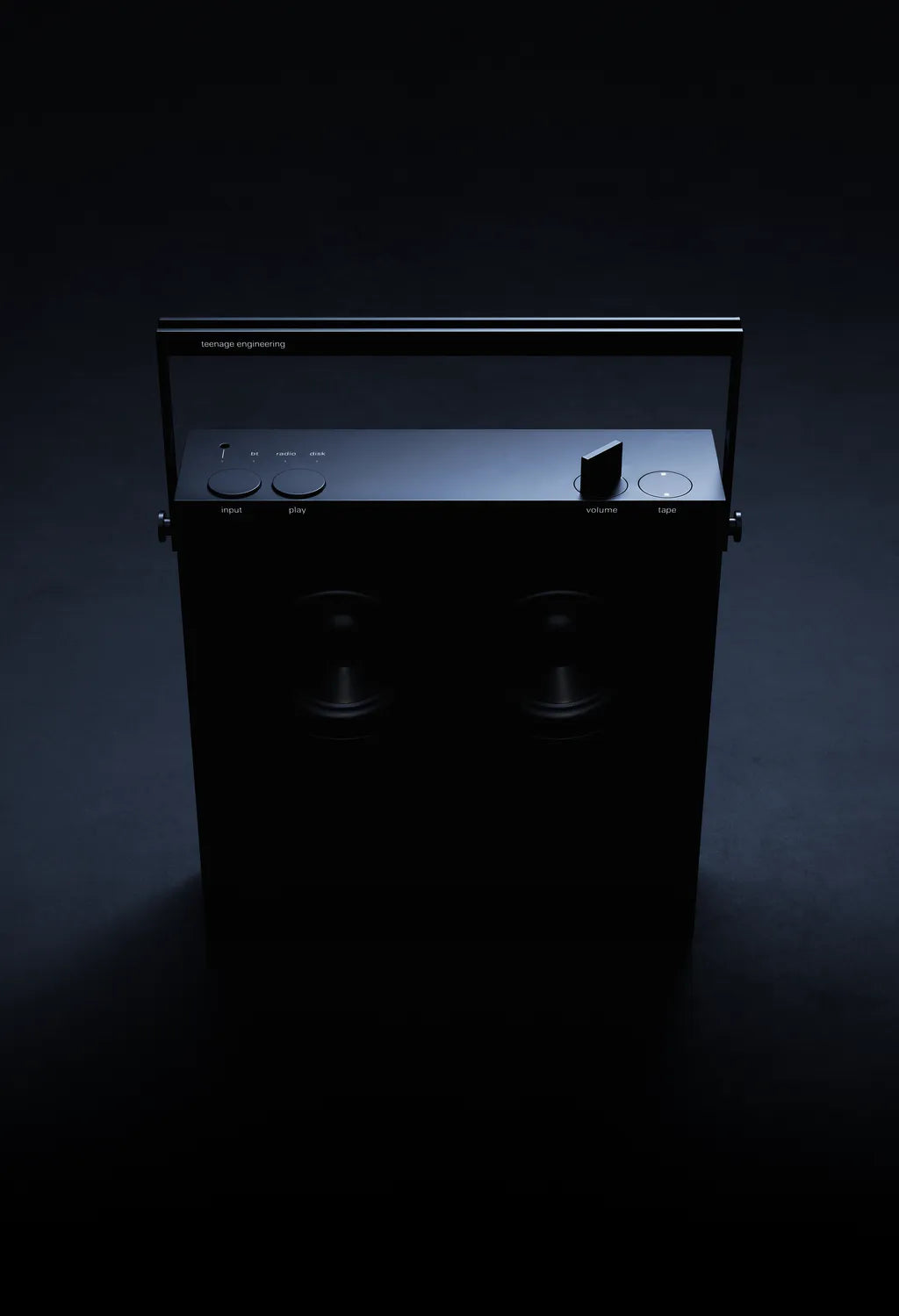 Black OB-4 speaker lit from above in a dark studio