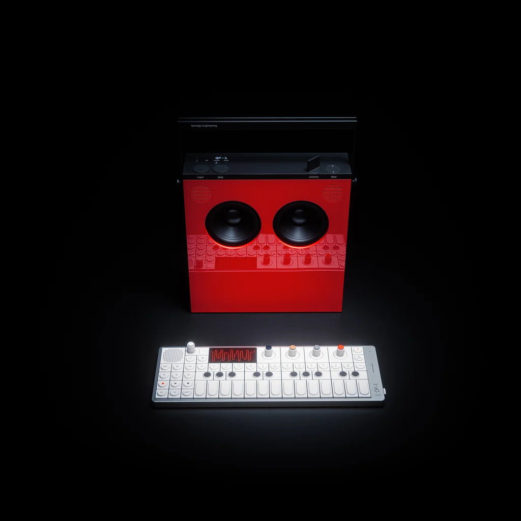 Red OB-4 speaker standing behind a white OP-1 field synthesizer