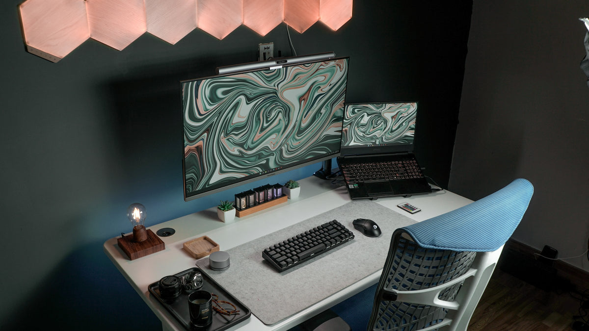 White desk against a dark teal wall with green marble screens and hexagon lights