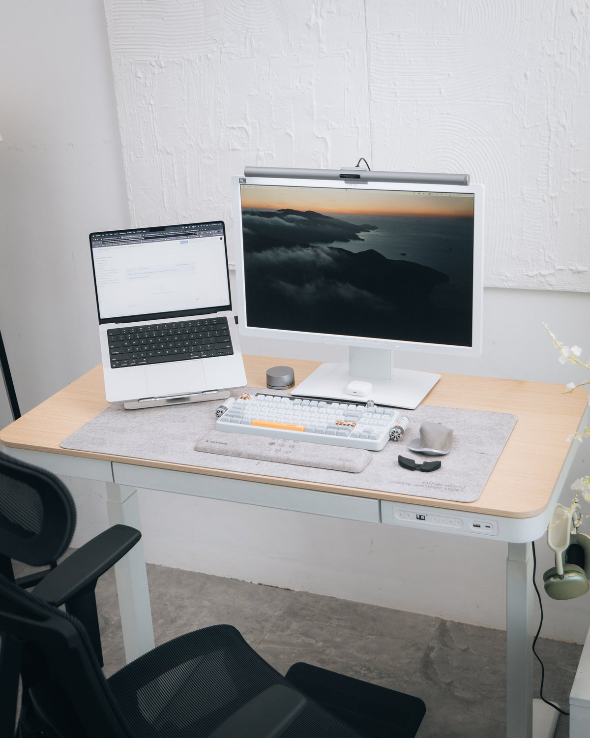 White desk with light oak top, monitor light bar, laptop stand and gray desk mat