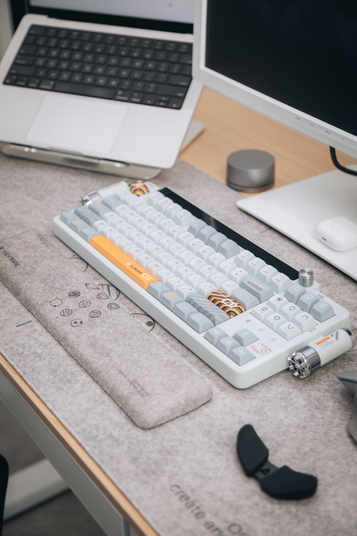 Retro-style mechanical keyboard with wrist rest on a gray felt desk mat