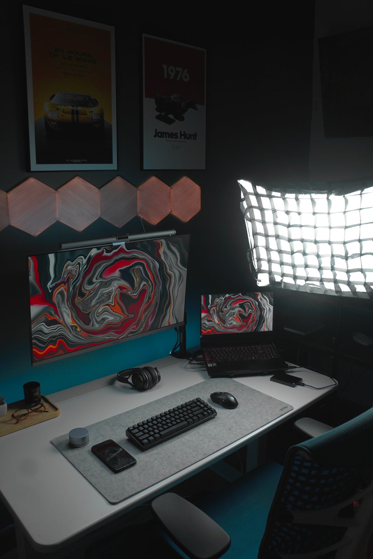 Dark desk with red wave wallpaper screens, softbox light and hexagon panels