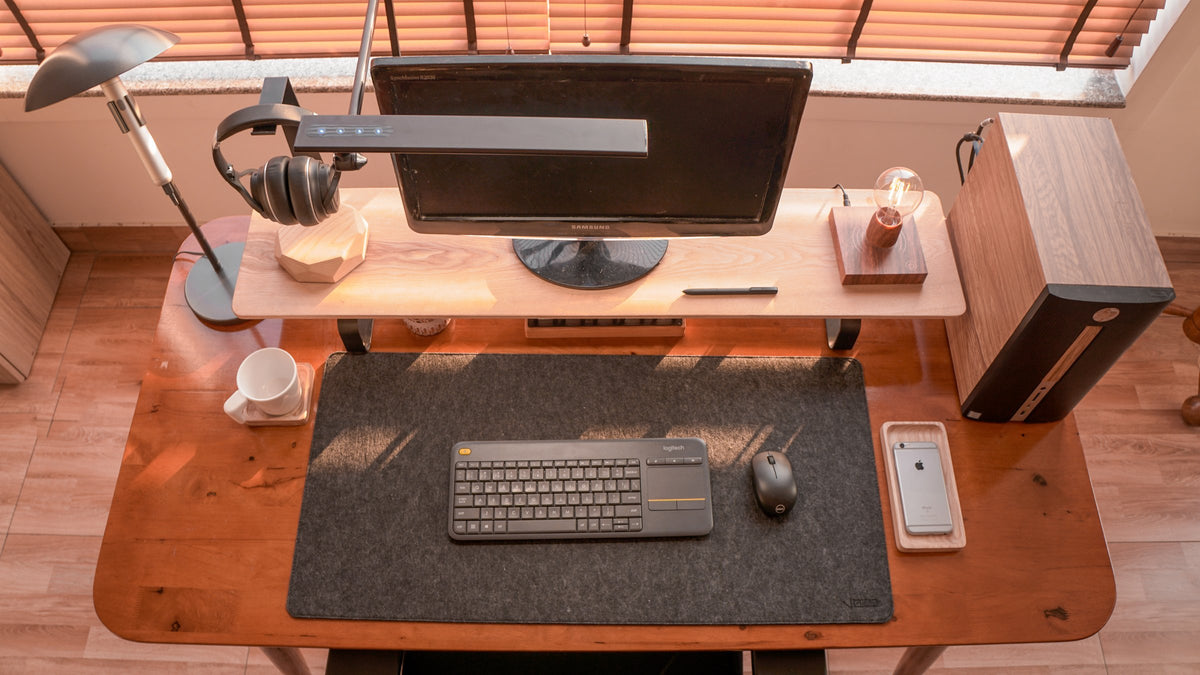 Walnut desk with a monitor riser shelf, headphones stand and levitating lamp