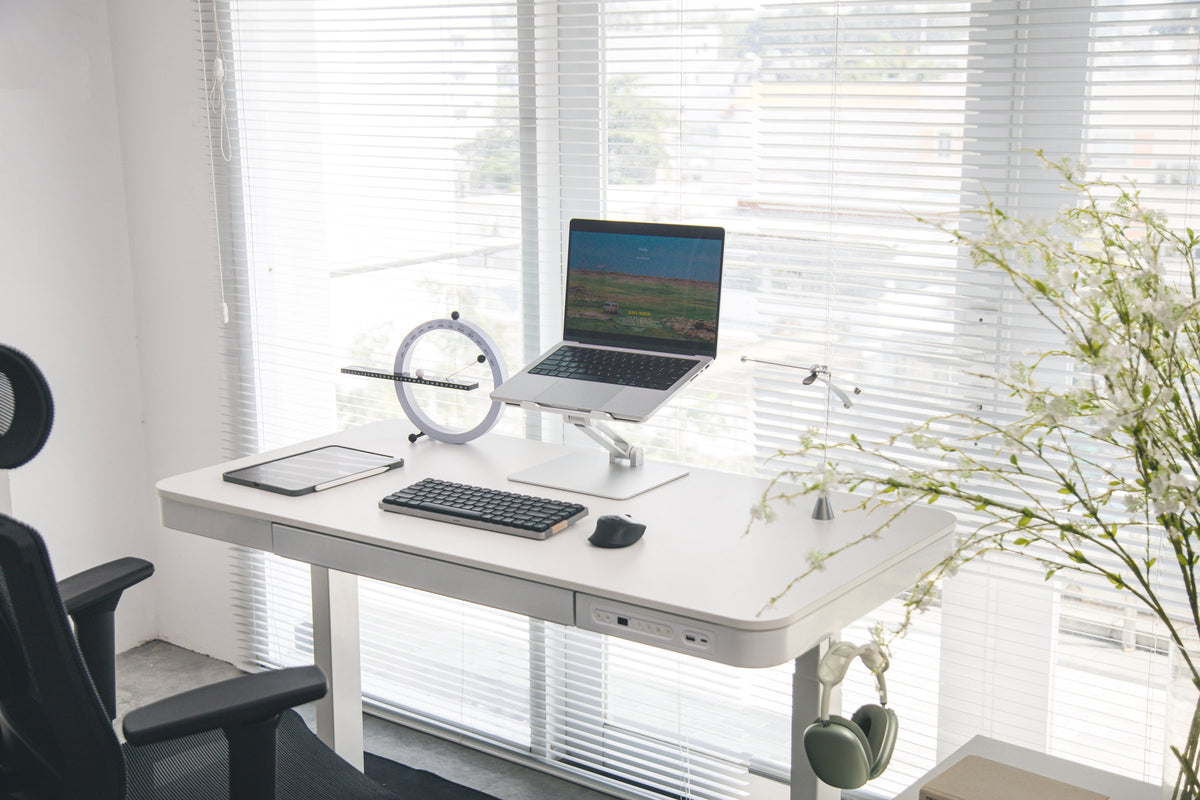 White all-in-one desk with a laptop stand, compact keyboard and a ring desk clock by bright blinds