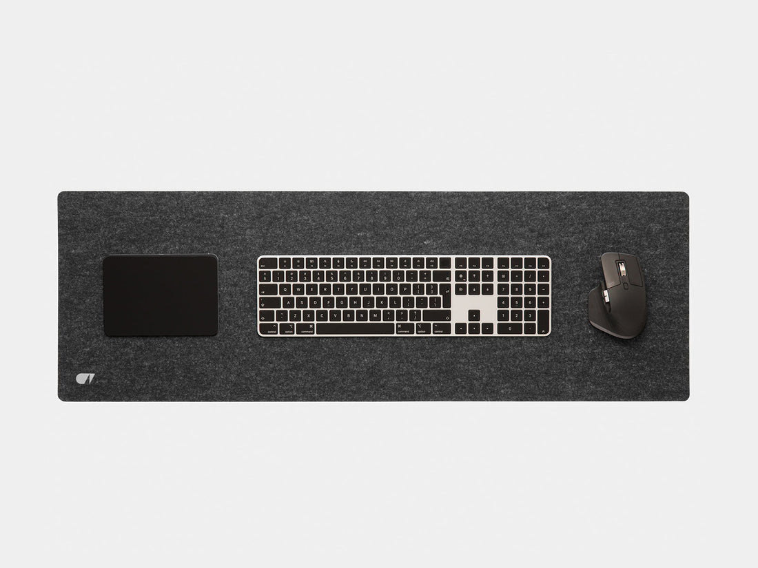 Anthracite felt desk mat from above with a keyboard, trackpad and mouse on it