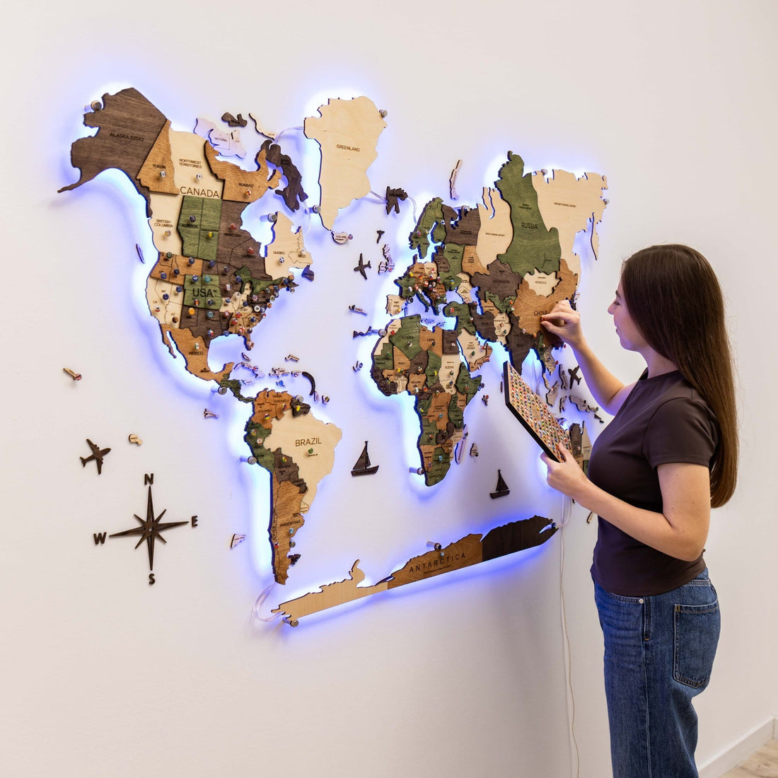 The map lit in blue and violet while a person holds a small wooden board
