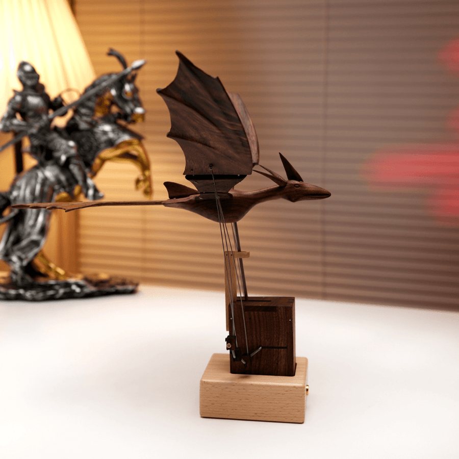 Dark dragon from the side above its tower and pale base, a knight figure and a lamp behind.