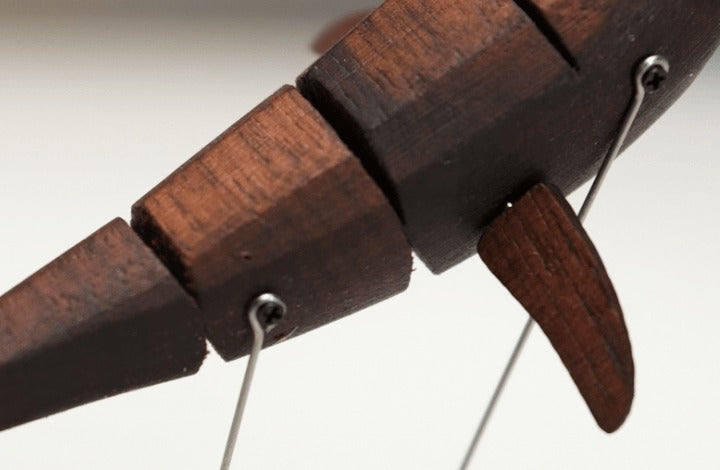 Close up of the narwhal segmented body with a small fin and a thin wire.