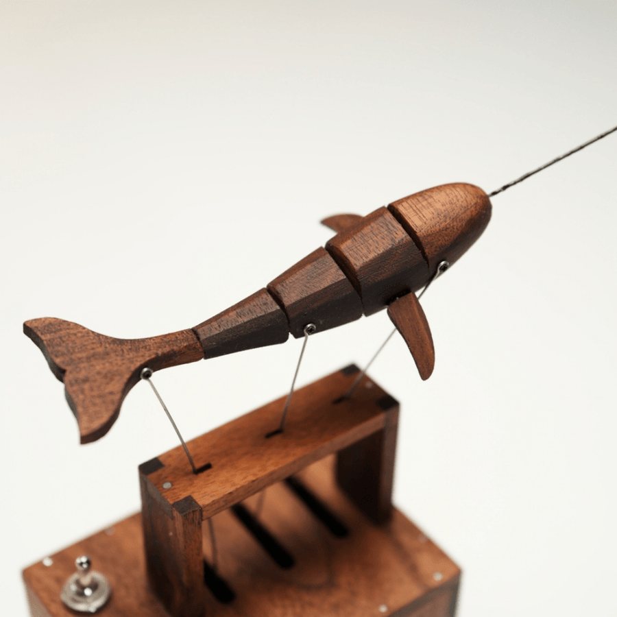 Narwhal from the side with its tail raised above the slotted frame on the box.