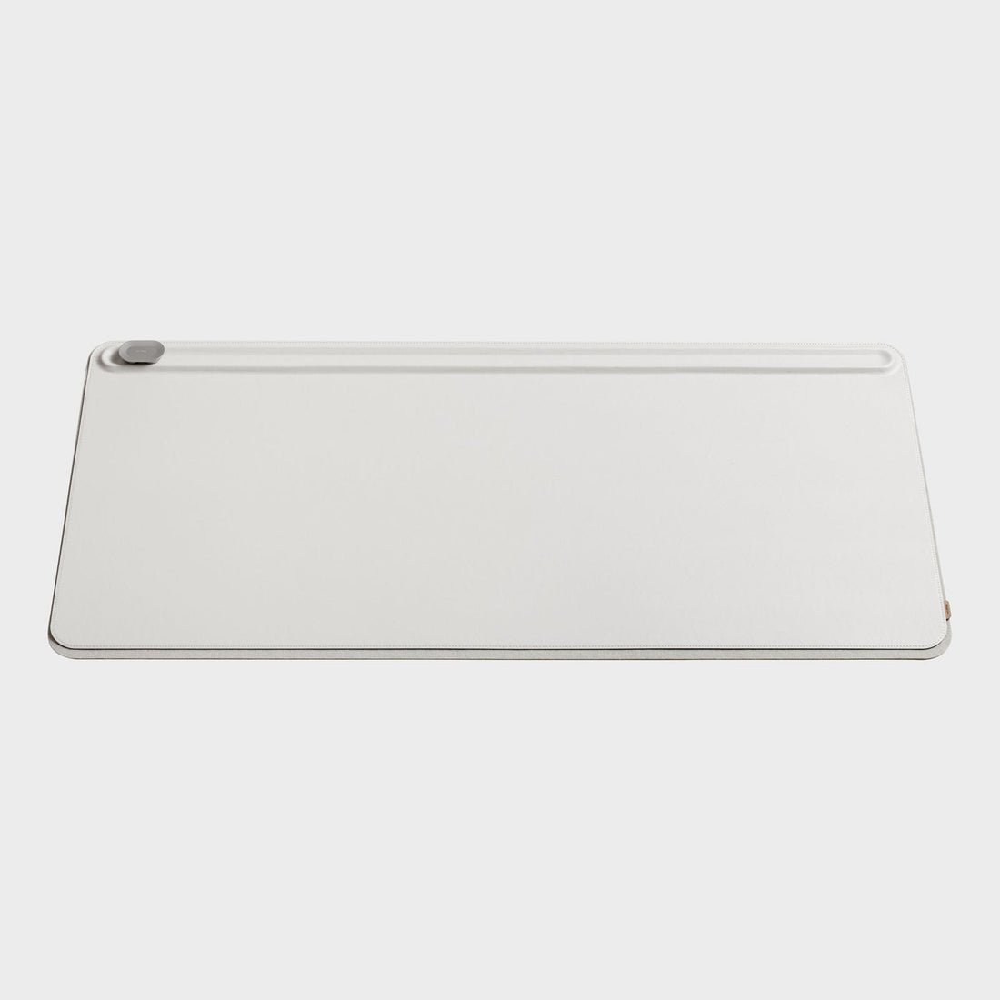 Stone colored desk mat from the front with a groove along the top edge