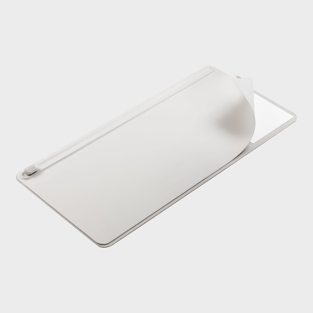 Stone colored desk mat at an angle with a corner lifted