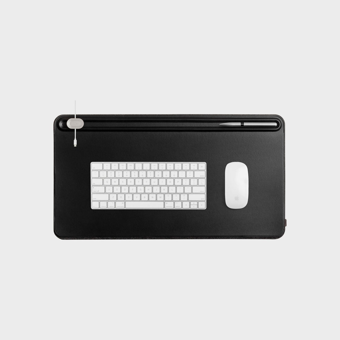 Medium black desk mat from above with a keyboard and mouse