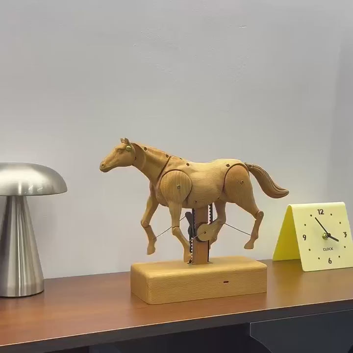 The wooden horse walking in place on its base, a metal lamp and a yellow clock behind.
