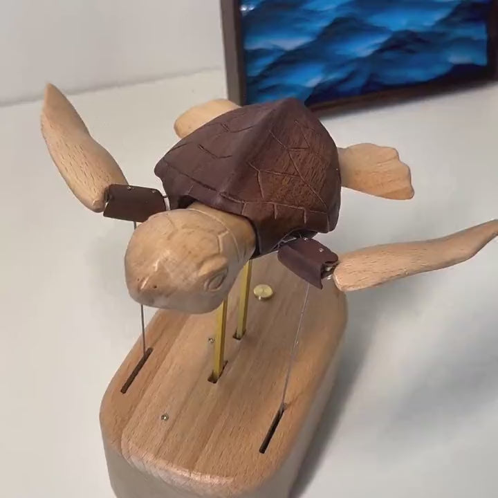 Sea turtle automaton from the front and slightly above, flippers sweeping, blue sea painting behind.