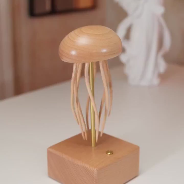 Jellyfish automaton on a white table with a pale sculpture behind, tentacles swaying, ending close on the bell.