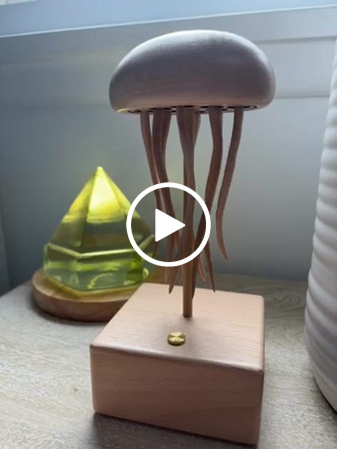 Jennifer E.: Jellyfish automaton with a grey bell beside a green glass ornament, from an owner clip.