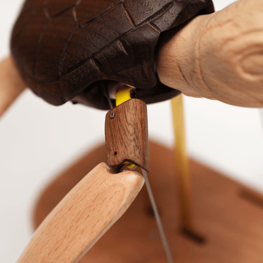The shoulder joint where a pale flipper is pinned to the dark shell, a brass rod below.
