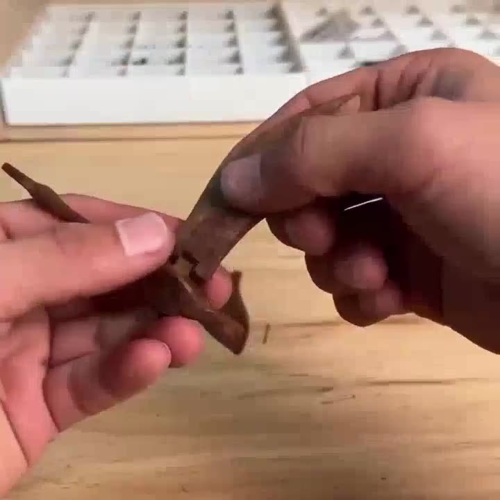 Hands fitting a wooden wing onto its joint